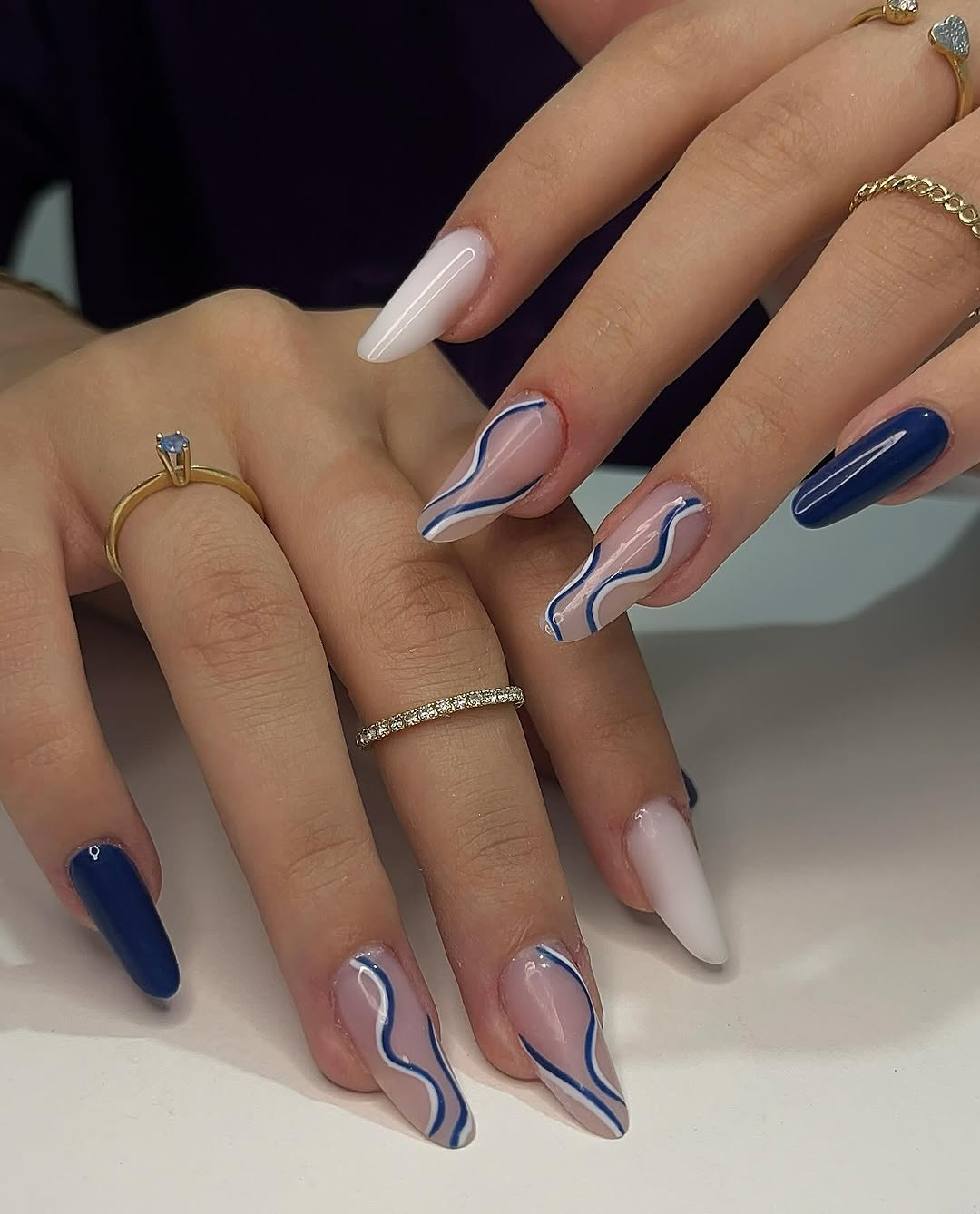 Unhas com swirls azuis sobre nude
